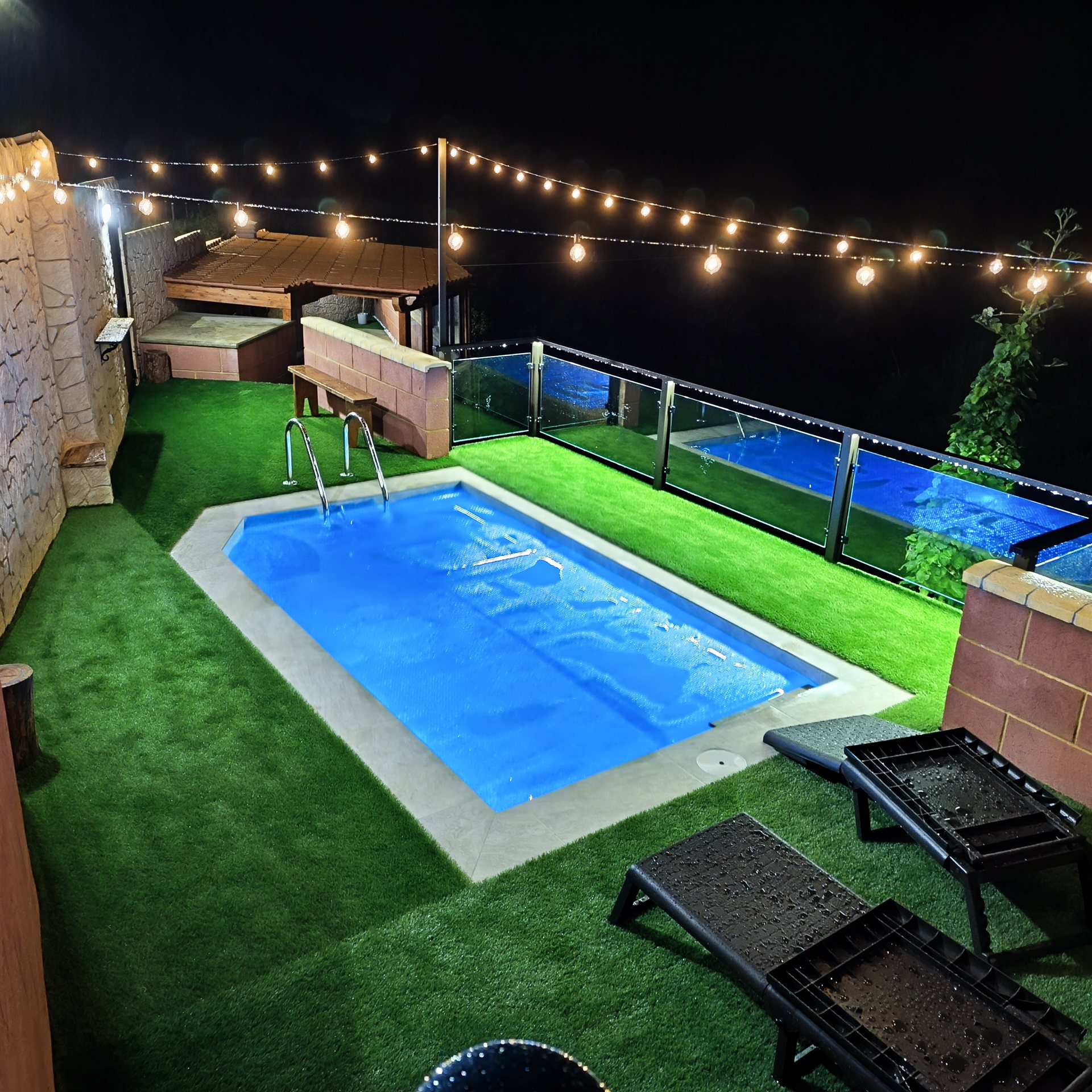 Piscina de El Guanche II de noche con guirnaldas de luz